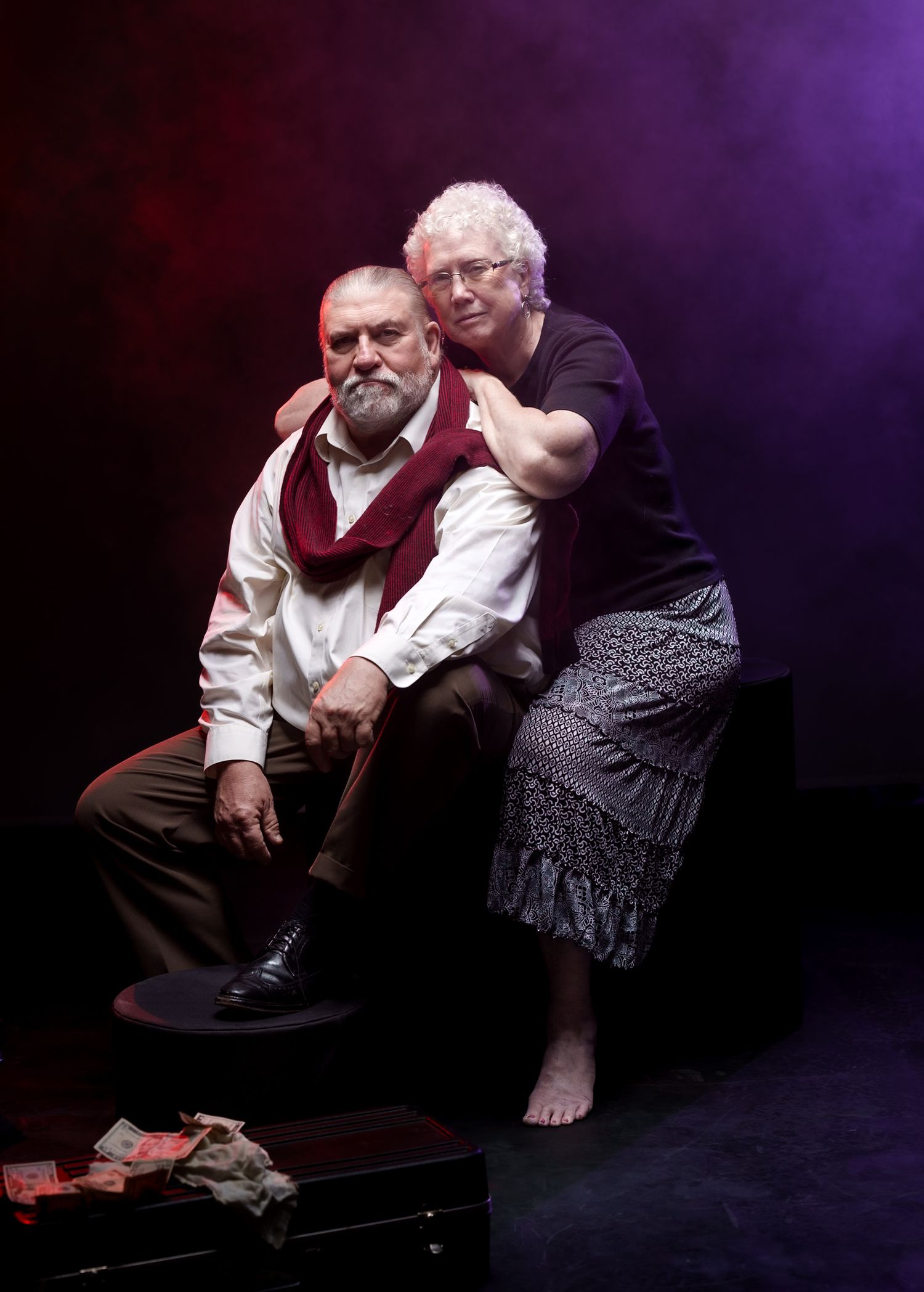 Dramatic studio portrait with theatrical purple lighting and vintage styling.