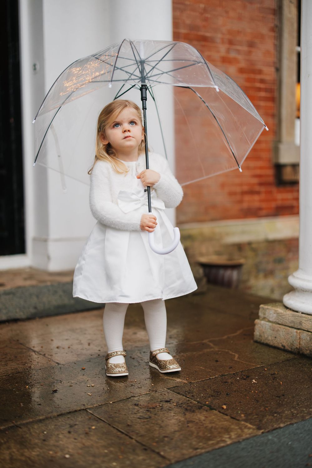 sweet little girl under umbrella in the rain