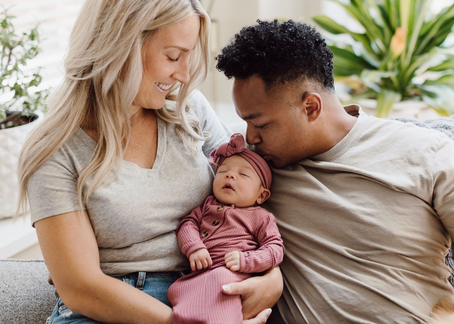 A family sharing a tender moment with their newborn baby at home.