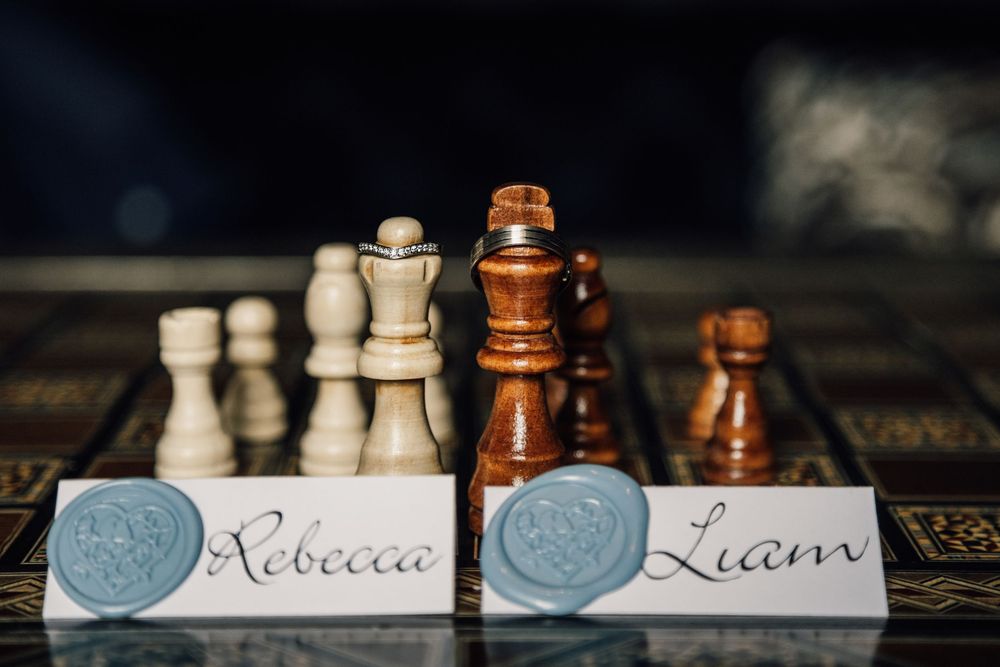 Chess pieces arranged on a dark surface with decorative text elements.
