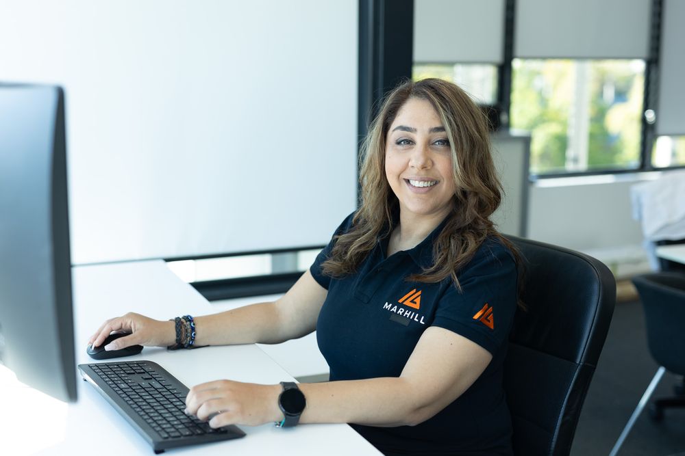 Professional at desk working on computer in modern office environment.