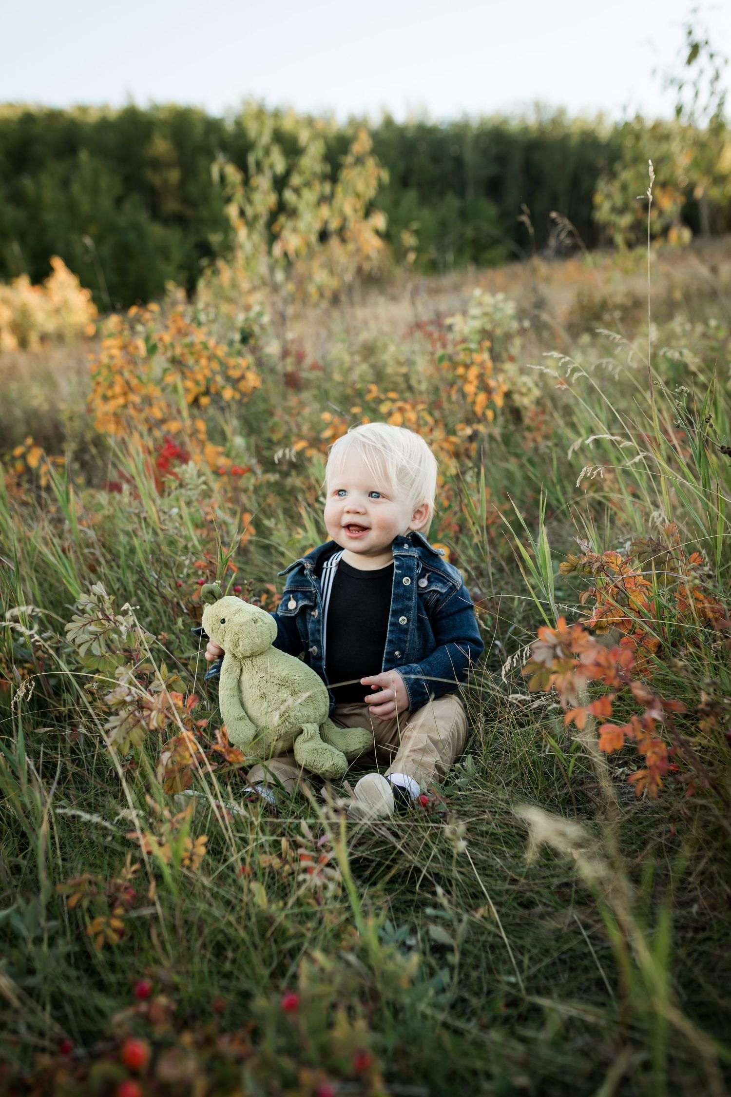 Cute baby in fall leaves during fall mini sessions in Calgary at Nose Hill Park by Love & Sunshine Photography.