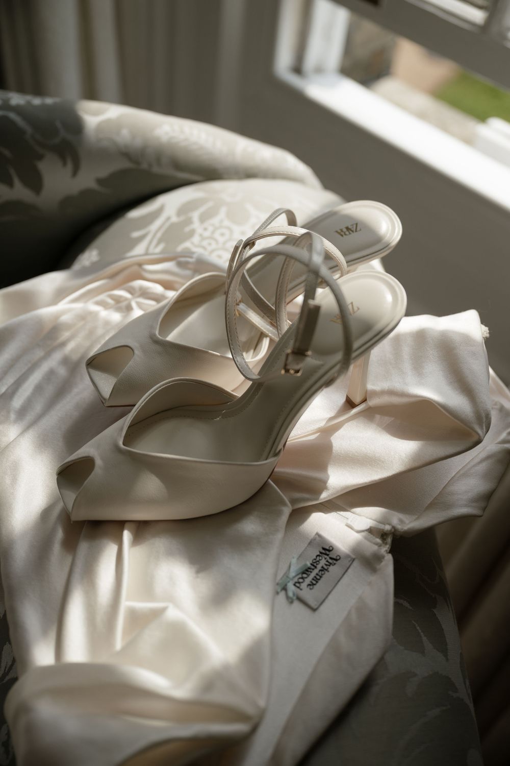 Elegant white bridal shoes with satin finish in natural window light.