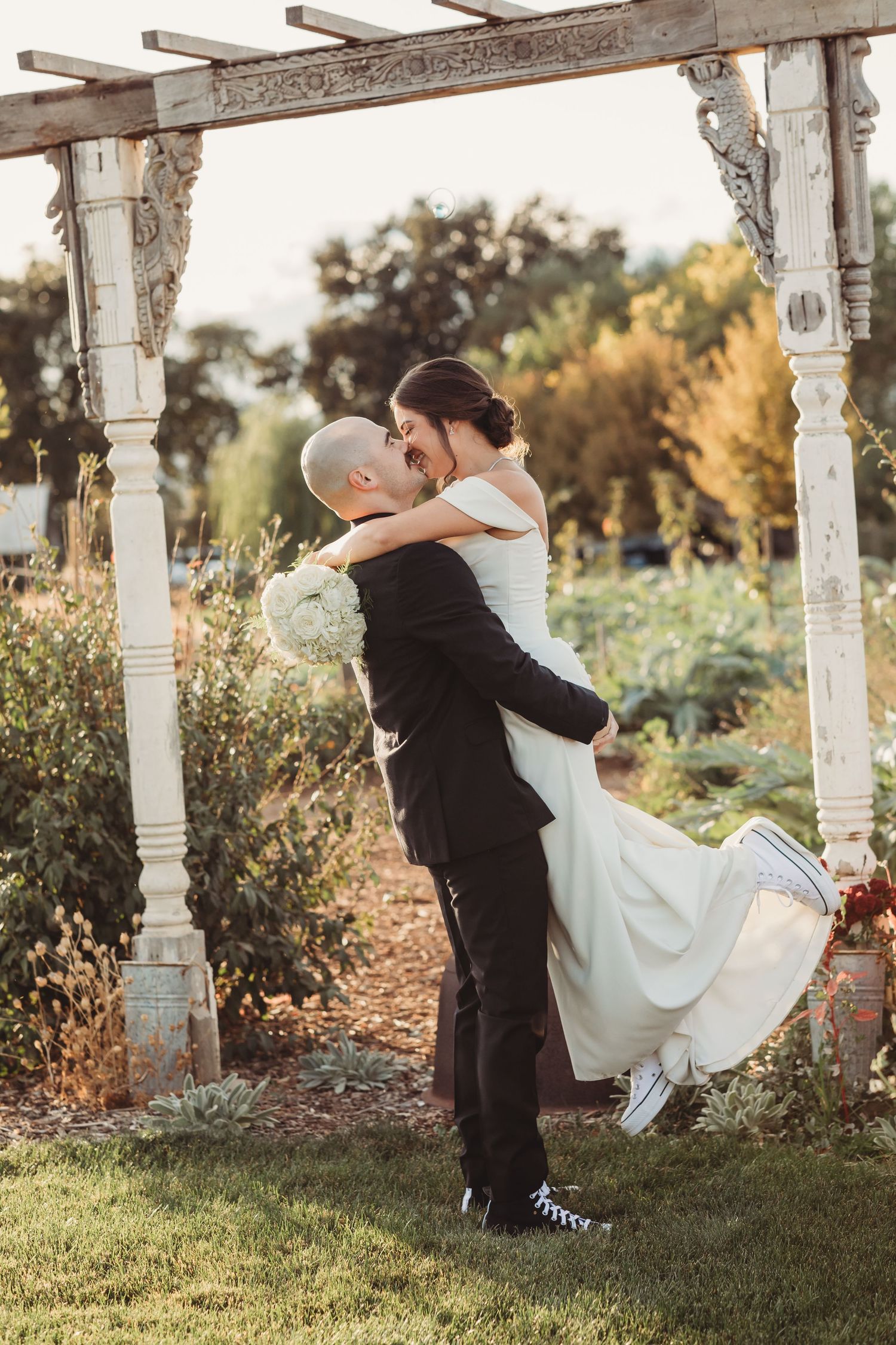 A romantic wedding sequence of a couple dancing in an outdoor garden setting at sunset with white pillars in the background.