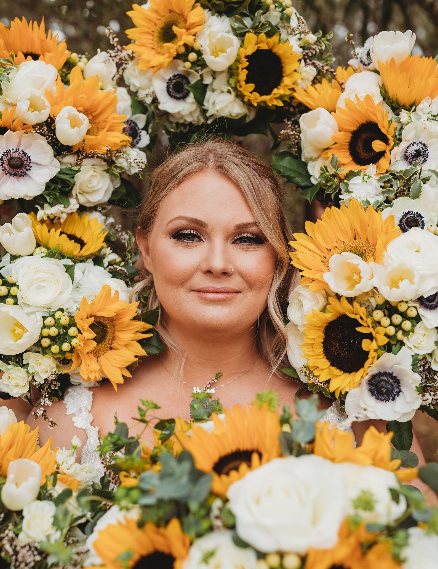 Bright sunflowers and white anemones create a stunning floral frame with yellow and white blooms and greenery.