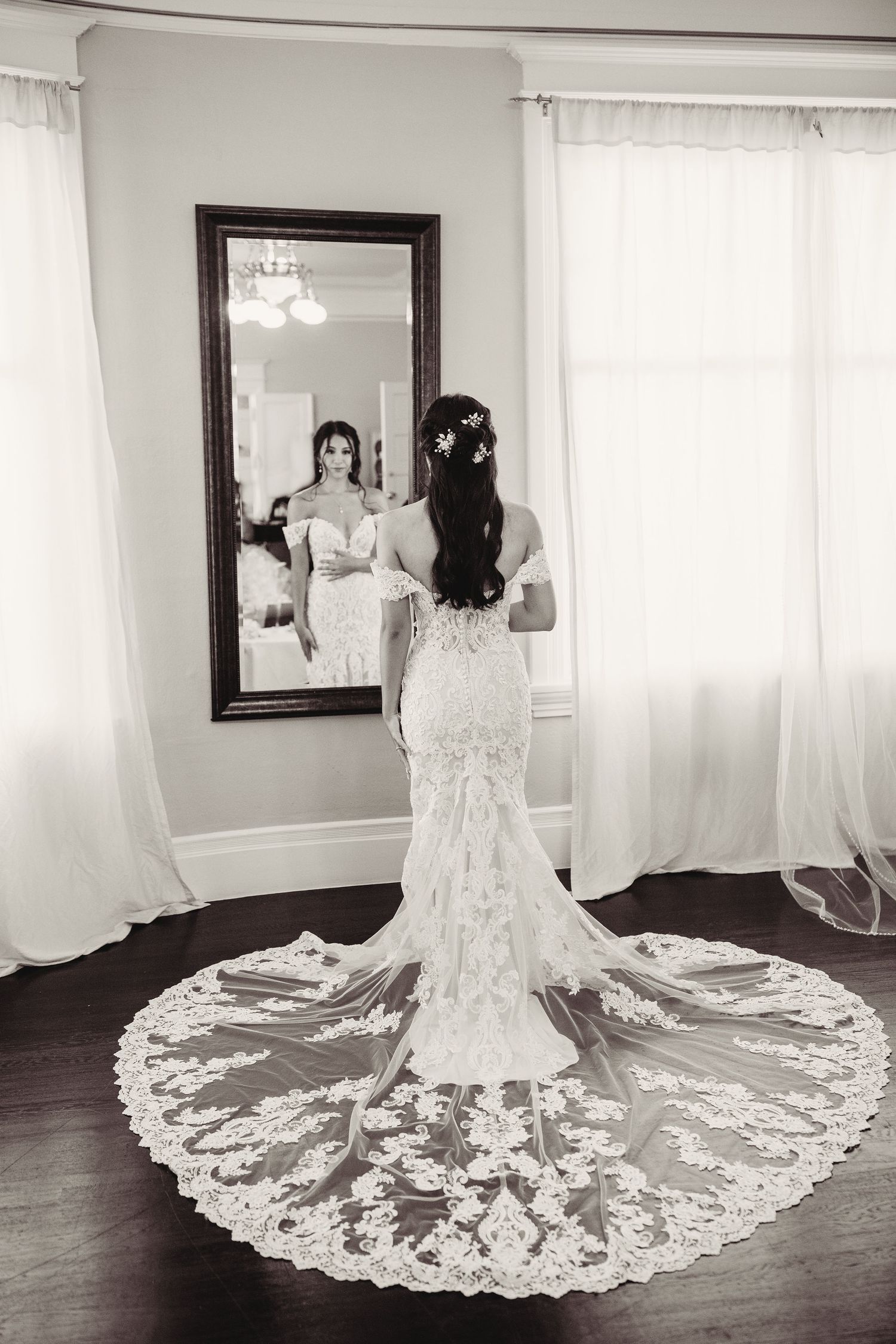 A dramatic bridal portrait series showcasing an elegant lace wedding dress with an ornate cathedral-length train.