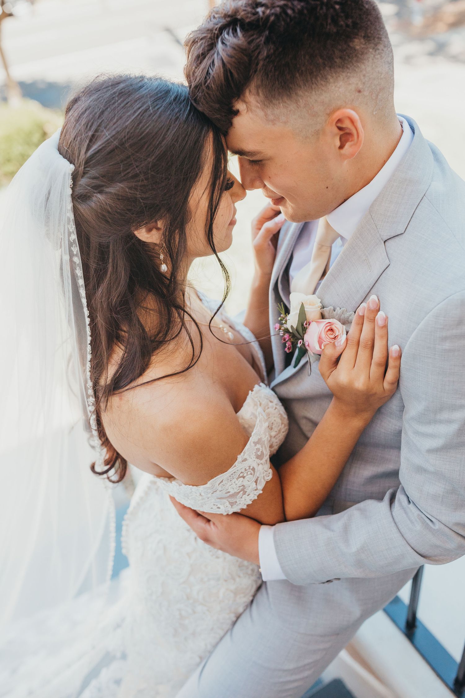 Close up of newlyweds sharing an intimate romantic moment together while dressed in wedding attire.