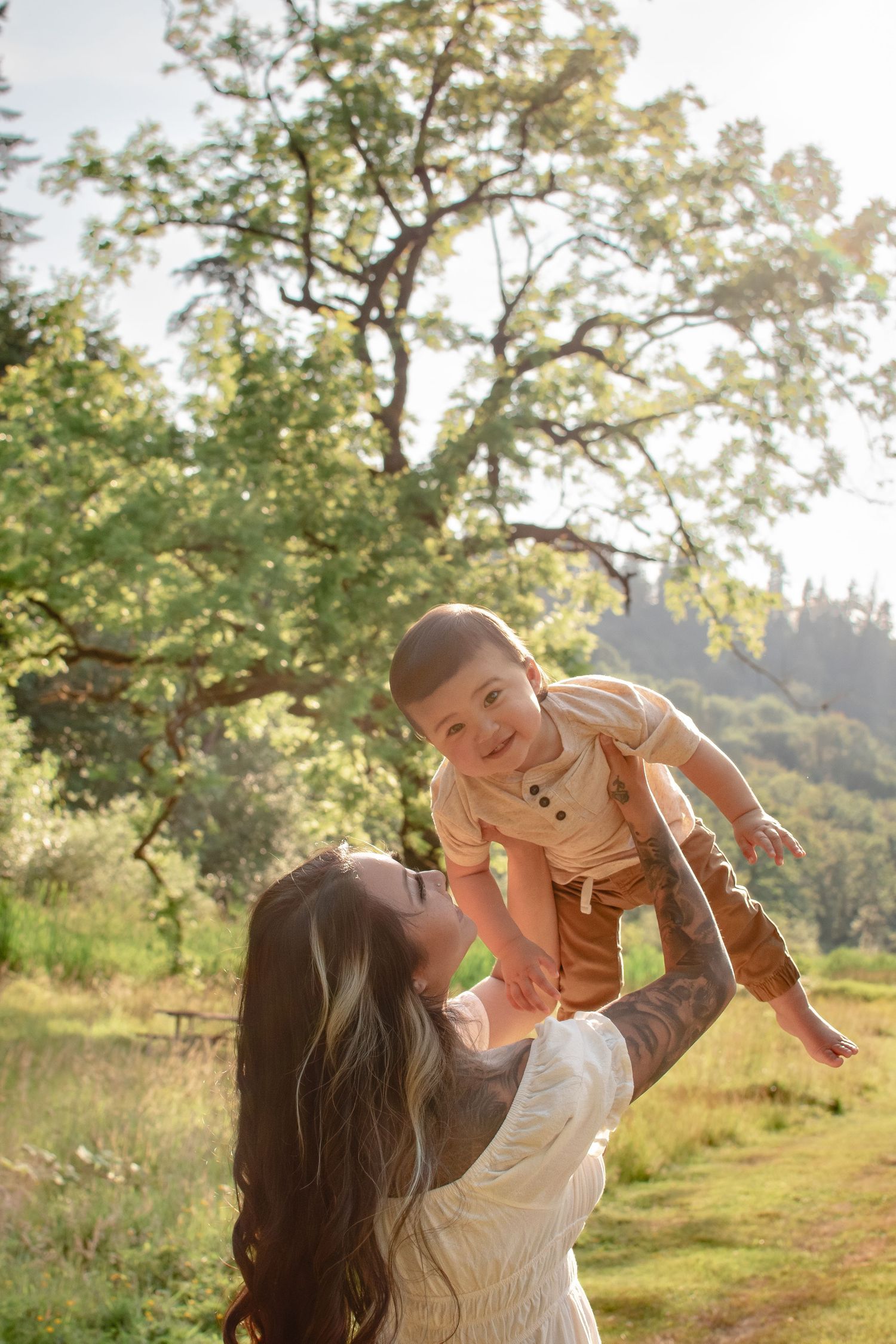 Mother lifting one-year-old during golden hour sunset session in Auburn, WA