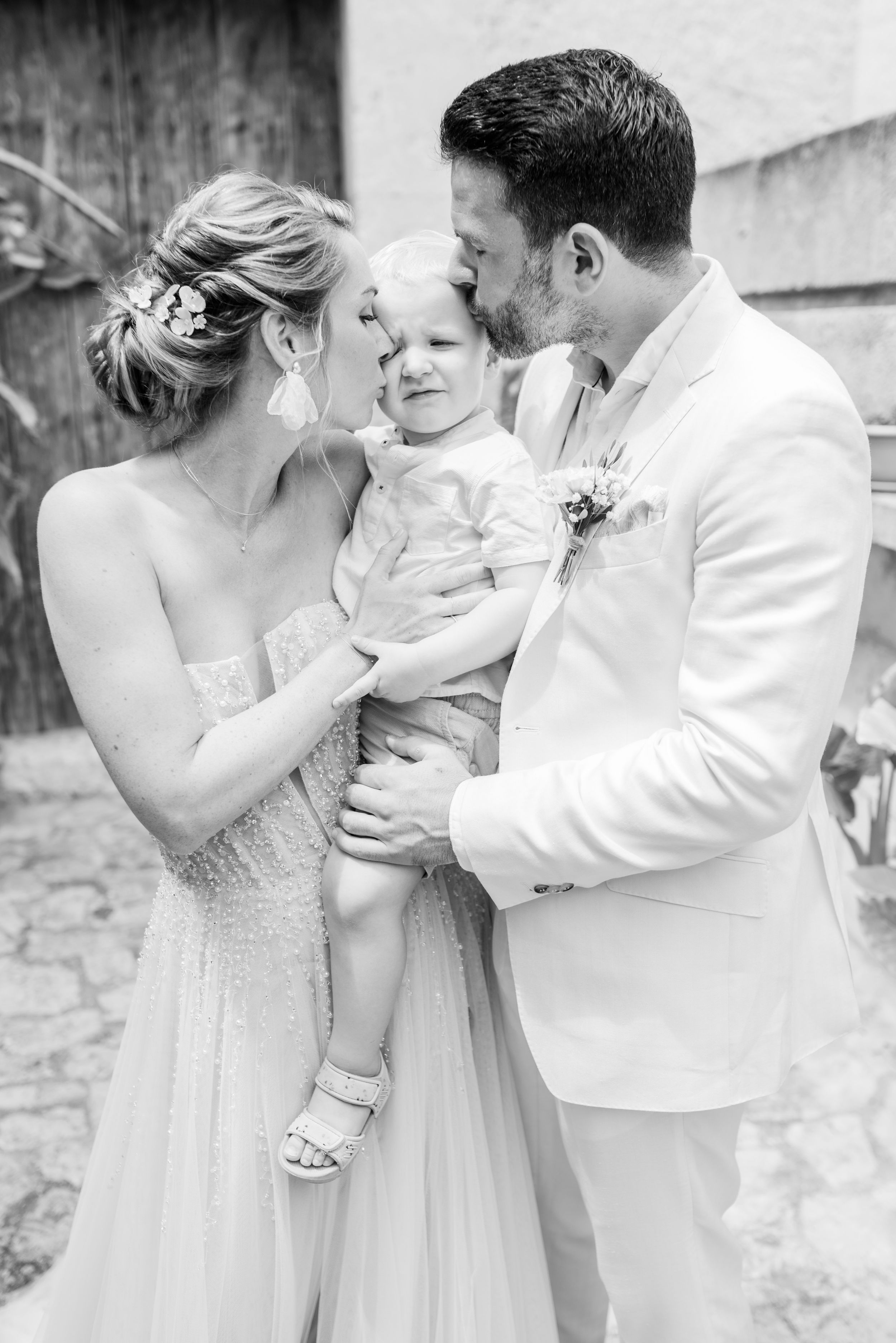 Ein wunderschöner Moment einer Hochzeit, festgehalten in Schwarz-Weiß, der die liebevolle Interaktion der Familie während der Feier zeigt.