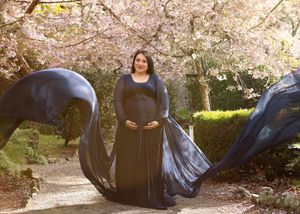 A sequence of images shows someone rolling and tumbling playfully under blooming cherry blossom trees in a park.