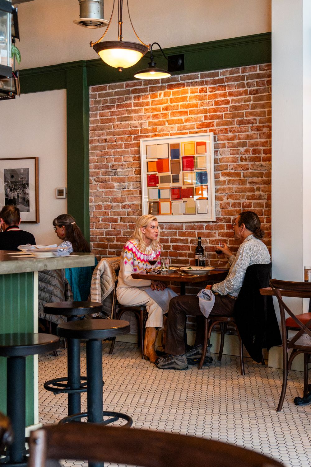 Restaurant interior with exposed brick walls, pendant lighting and modern artwork.