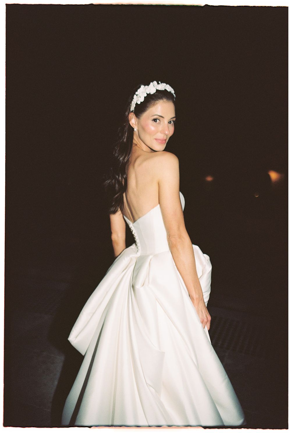 A bride wearing a classic white ball gown poses gracefully during an evening photo session.
