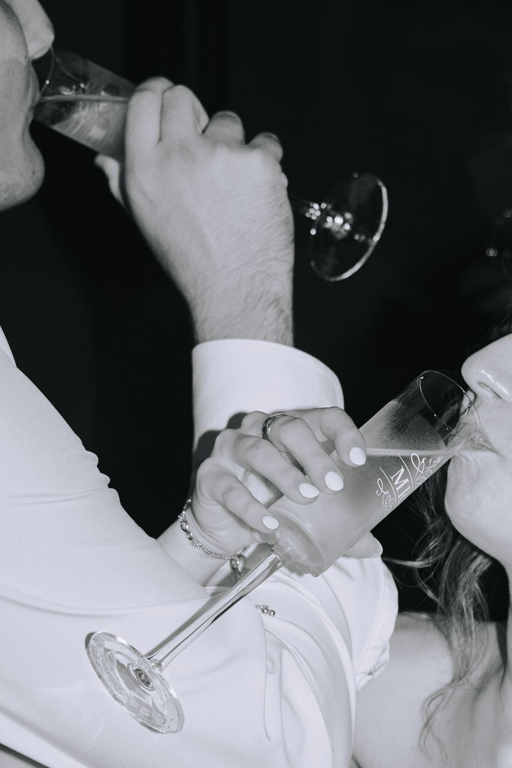 Close-up shot of champagne glasses clinking during a wedding toast celebration.