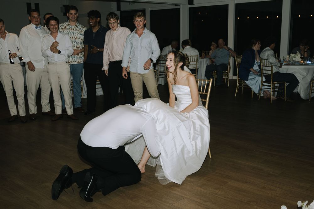 Wedding reception tradition captured as guests gather around the dance floor during a special moment.