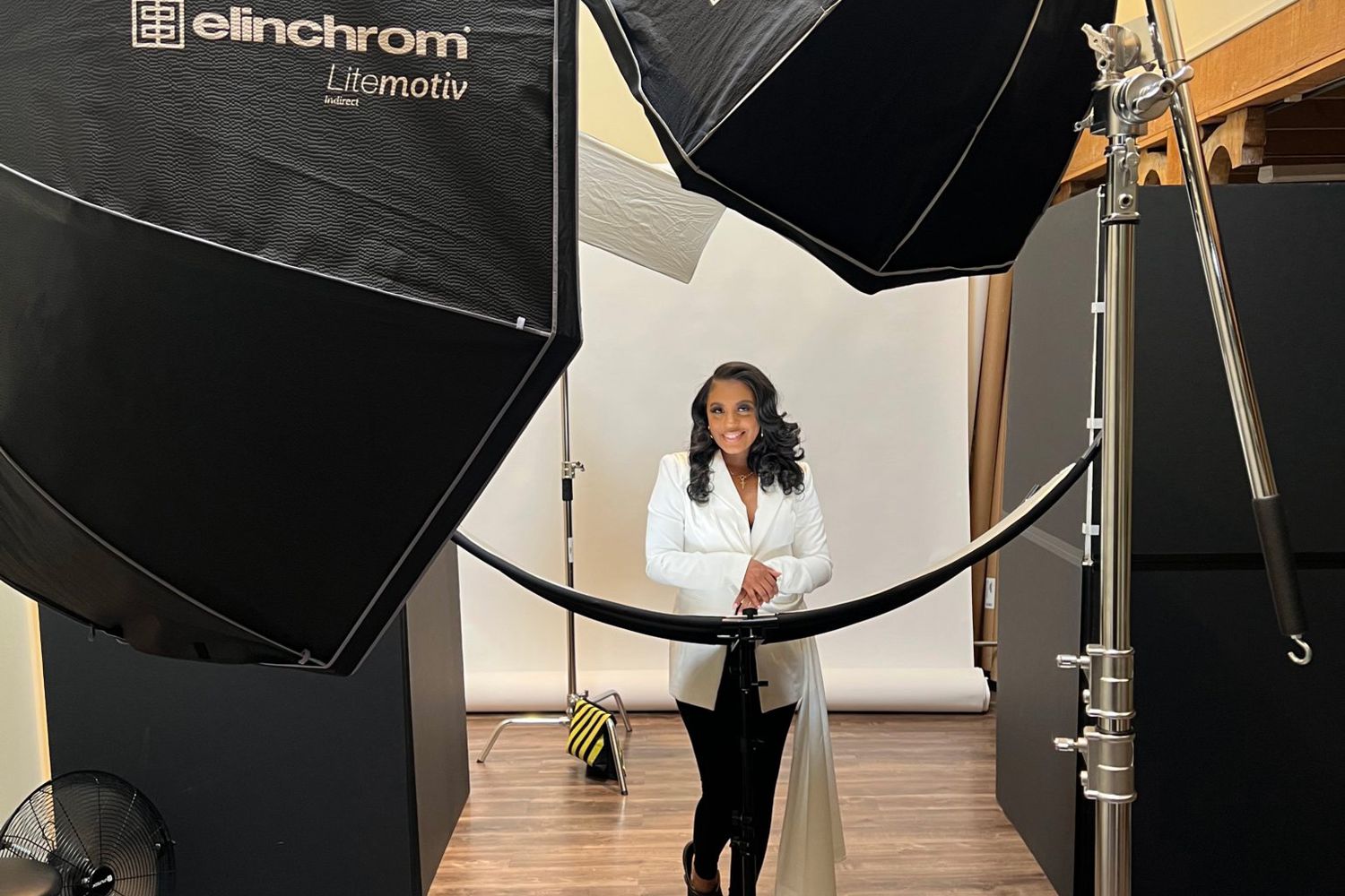 Behind the scenes photo showing photography studio setup with lighting equipment.