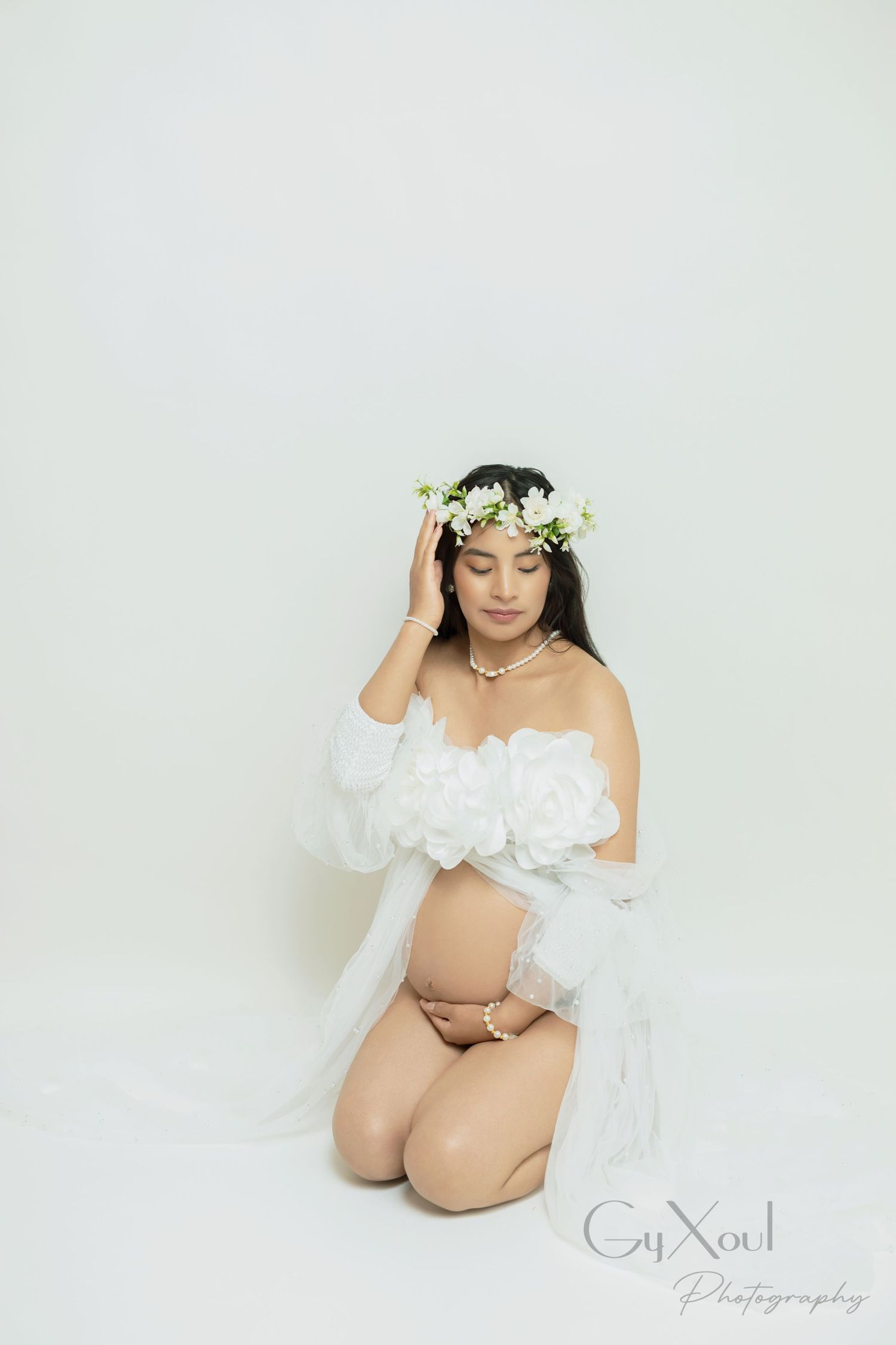 Artistic maternity portraits with soft lighting show an expectant mother in ethereal white against a light backdrop.