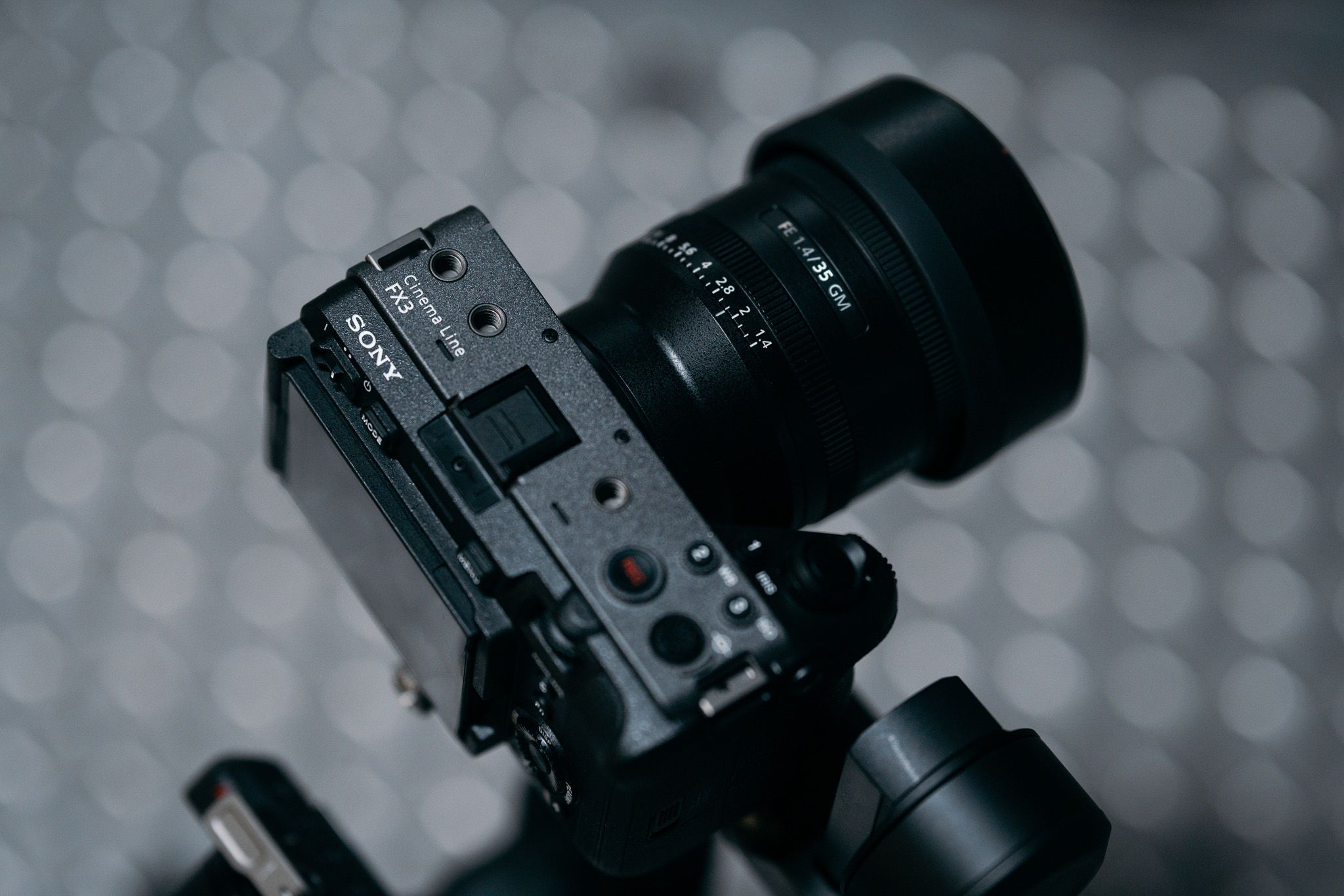 Black Sony mirrorless digital camera with mounted lens against bokeh background.