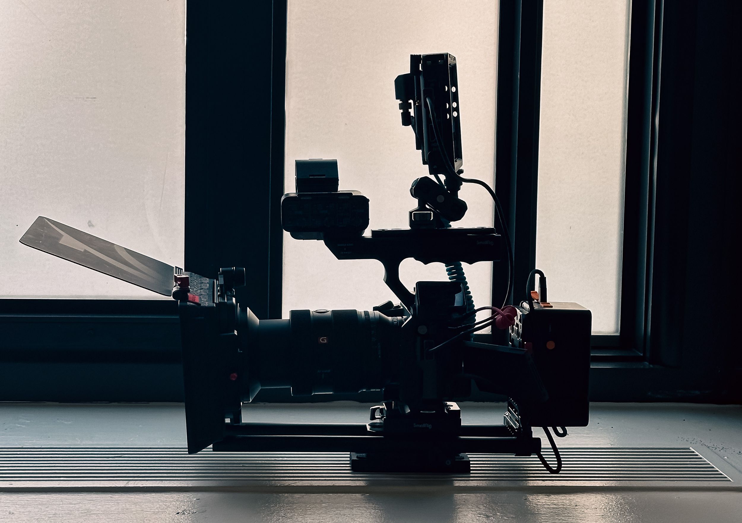 Silhouetted fitness equipment and machines in a modern gym against bright windows.