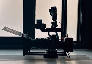 Silhouetted fitness equipment and machines in a modern gym against bright windows.