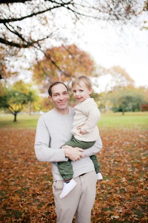 A parent and child share playful moments among autumn leaves in a park setting, captured in a series of candid photographs.