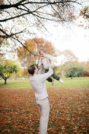 A playful scene in a park with autumn leaves scattered on the ground creating a warm, seasonal atmosphere.