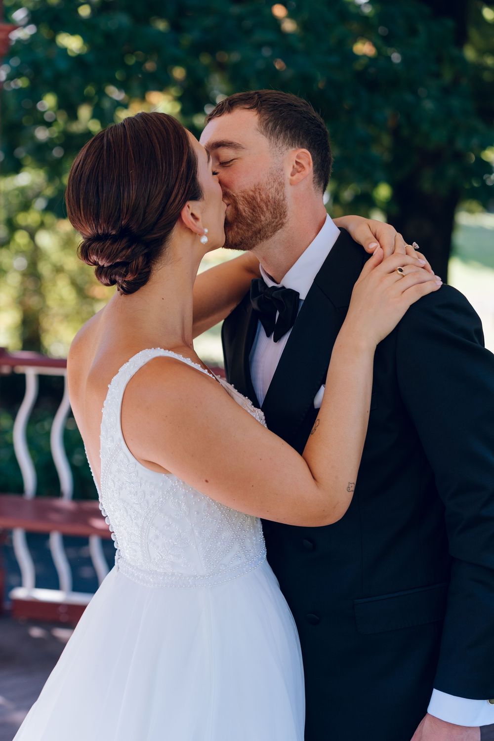 A romantic wedding moment captured as newlyweds embrace in a garden setting.