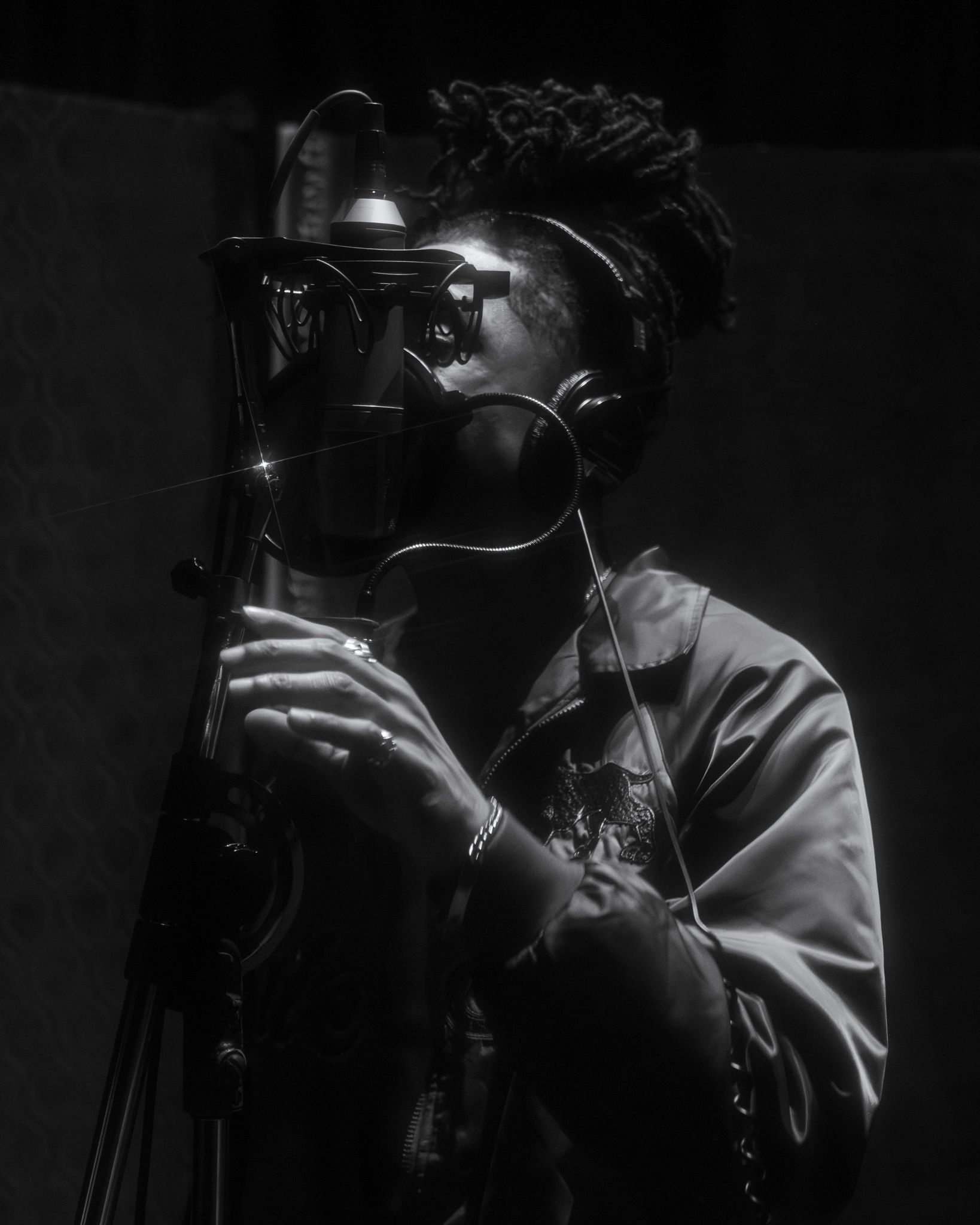 A silhouetted camera operator films in low light conditions with professional video equipment.