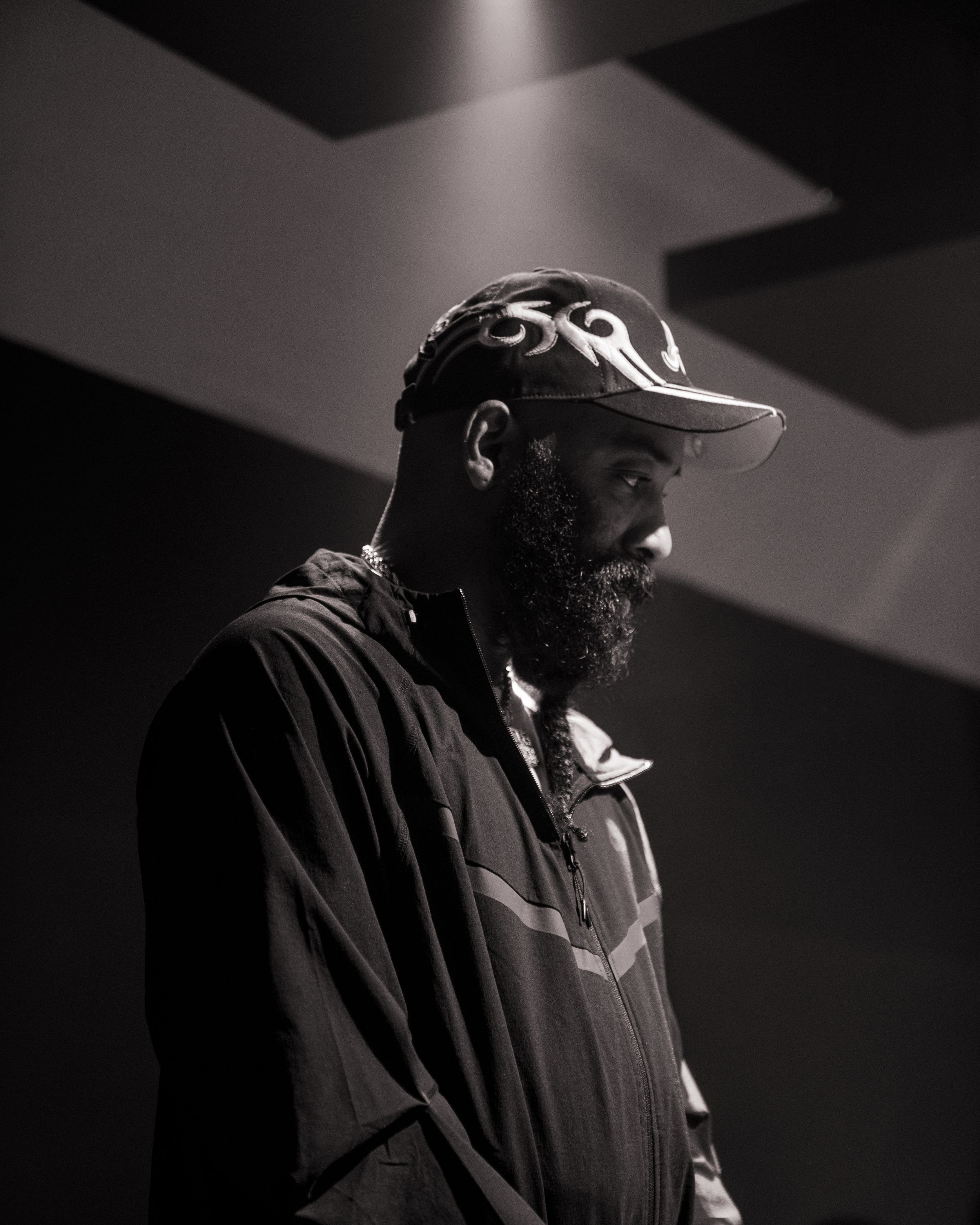 A dramatic black and white portrait series showing a person in a baseball cap and jacket in moody lighting.