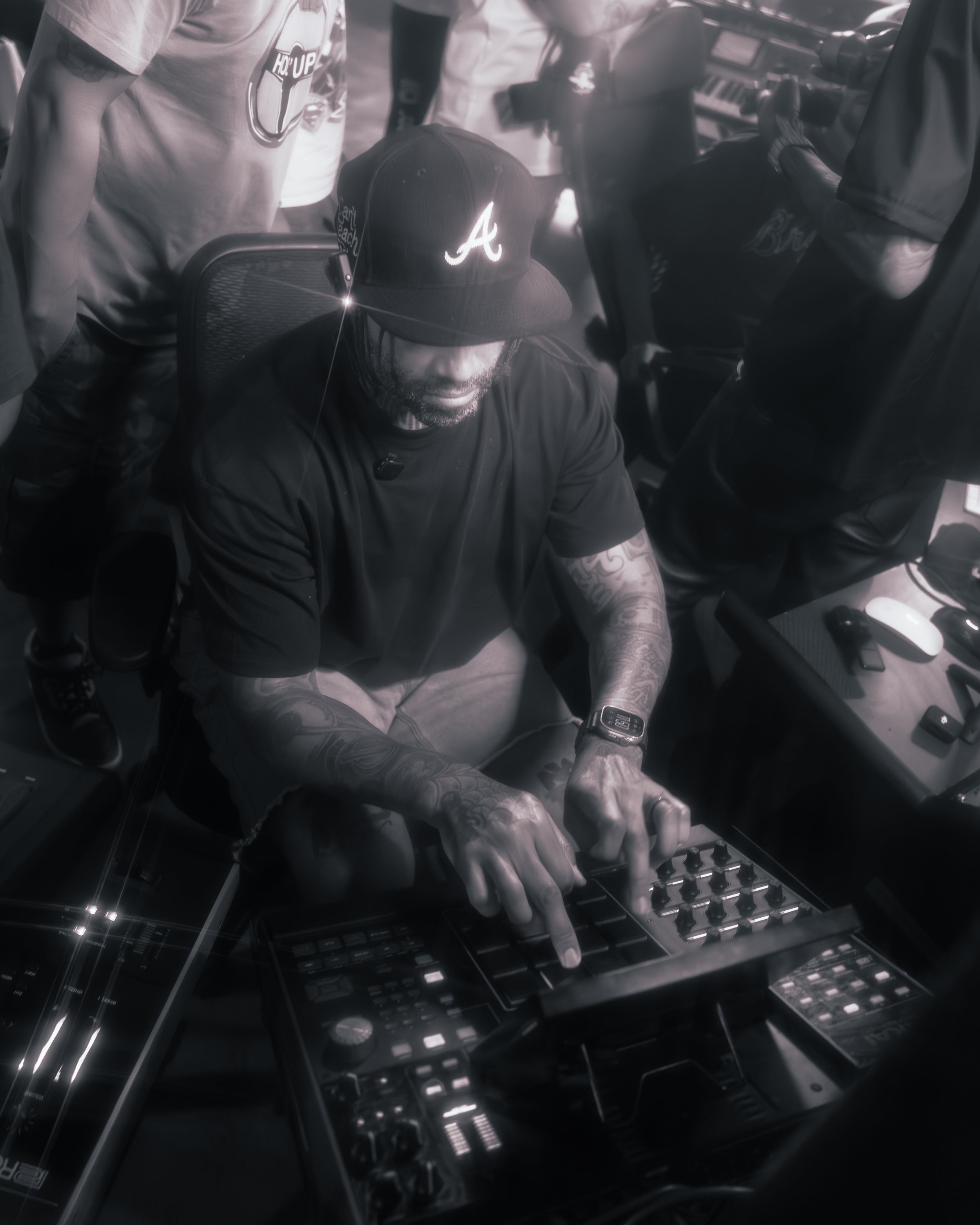 DJ performs at a nightclub using turntables and mixer equipment in a dark atmospheric setting.
