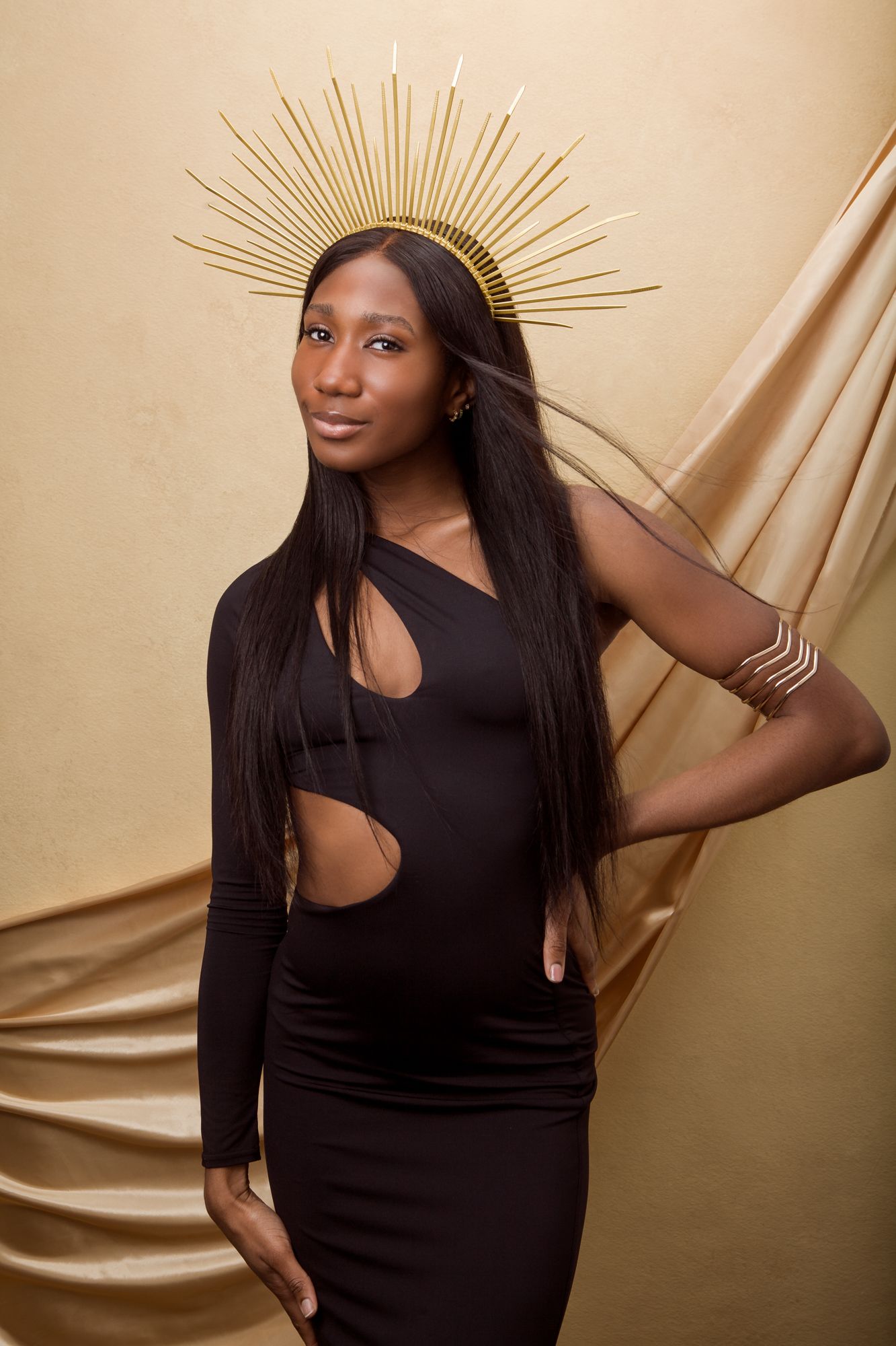 Elegant fashion series in black dress against champagne-colored silk backdrop with dramatic lighting.