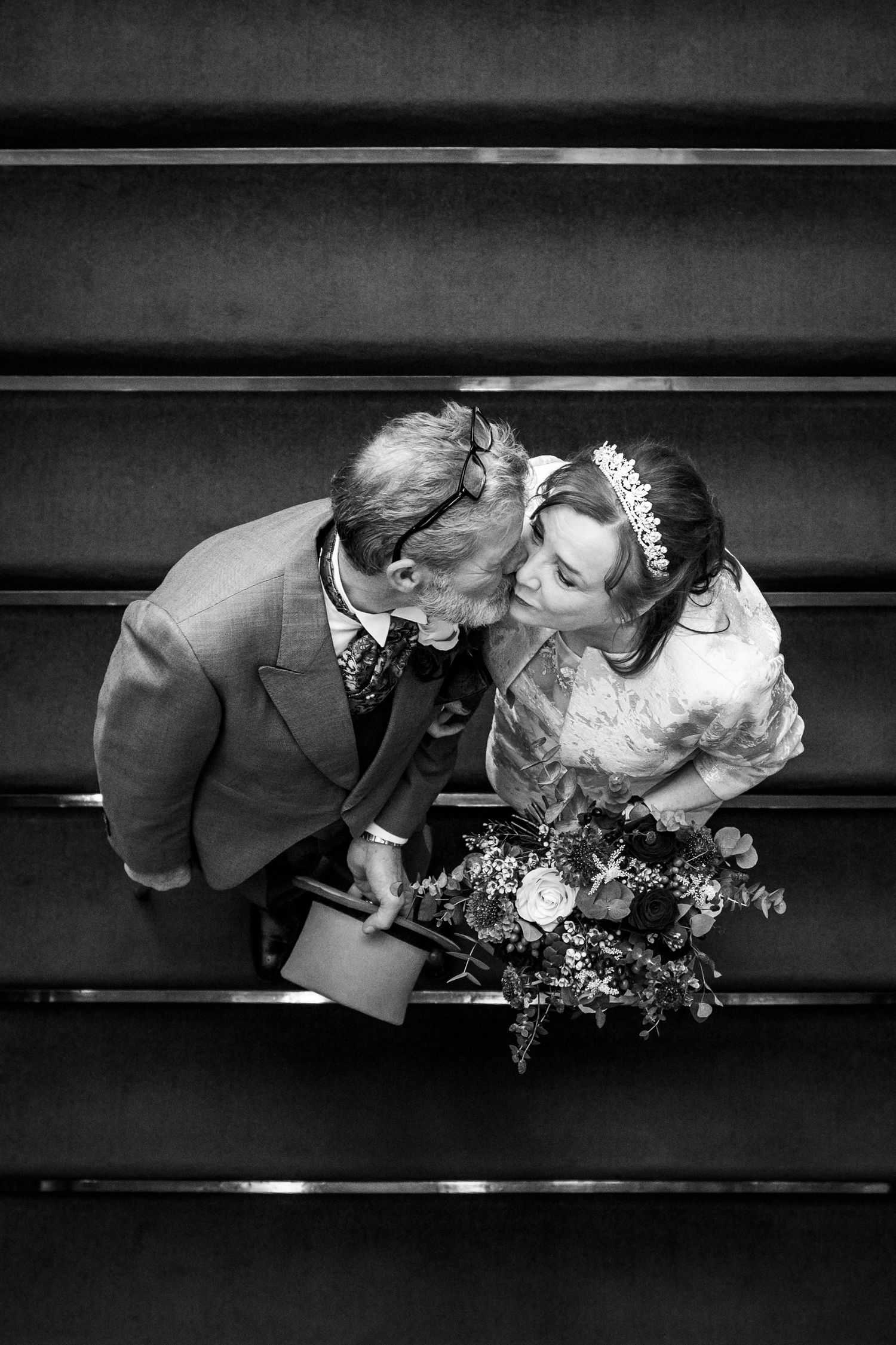 Bride and groom embracing on the staircase at Southport Town Hall after their wedding ceremony, relaxed natural portrait