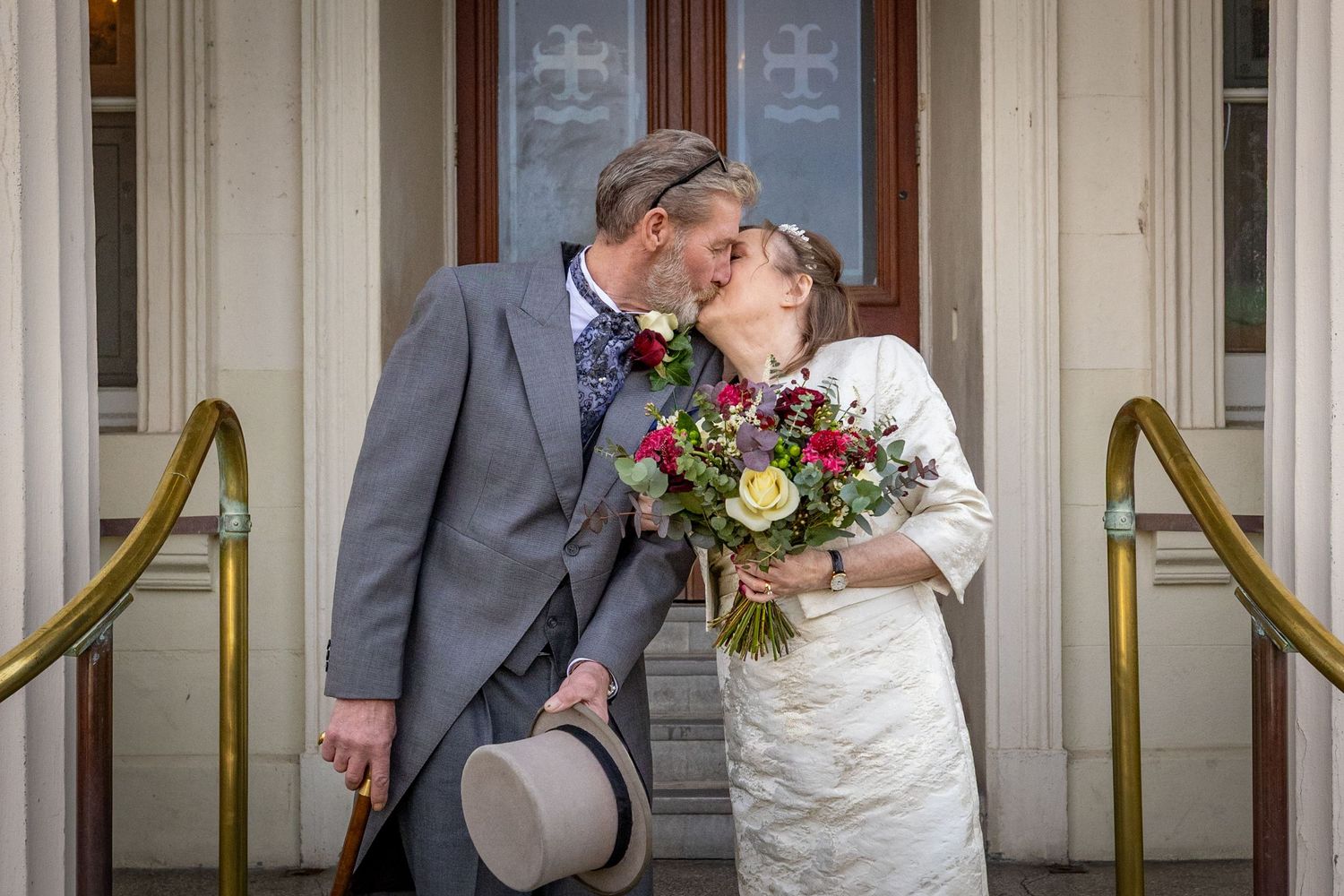 Bride and groom kissing on the steps of Southport Town Hall after their ceremony, relaxed documentary wedding photography