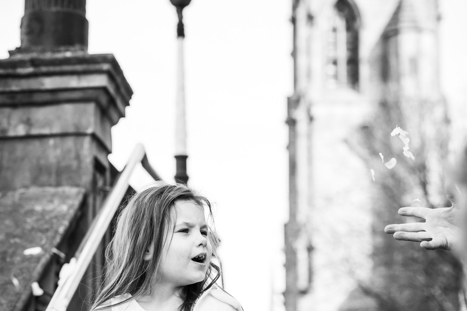 Child reacting to confetti outside Southport Town Hall during wedding celebrations, natural documentary moment