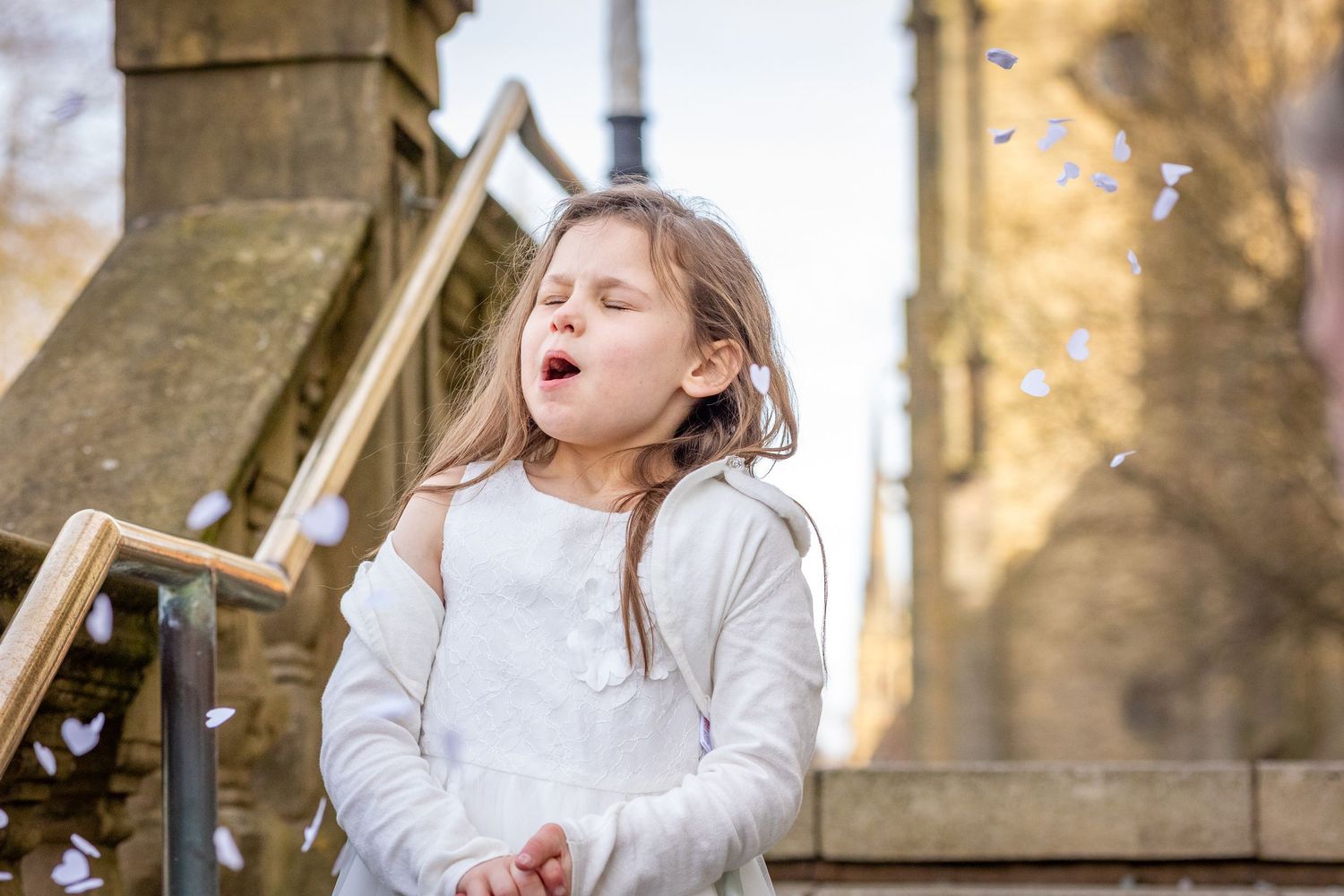 Child reacting to confetti outside Southport Town Hall during wedding celebrations, natural documentary moment