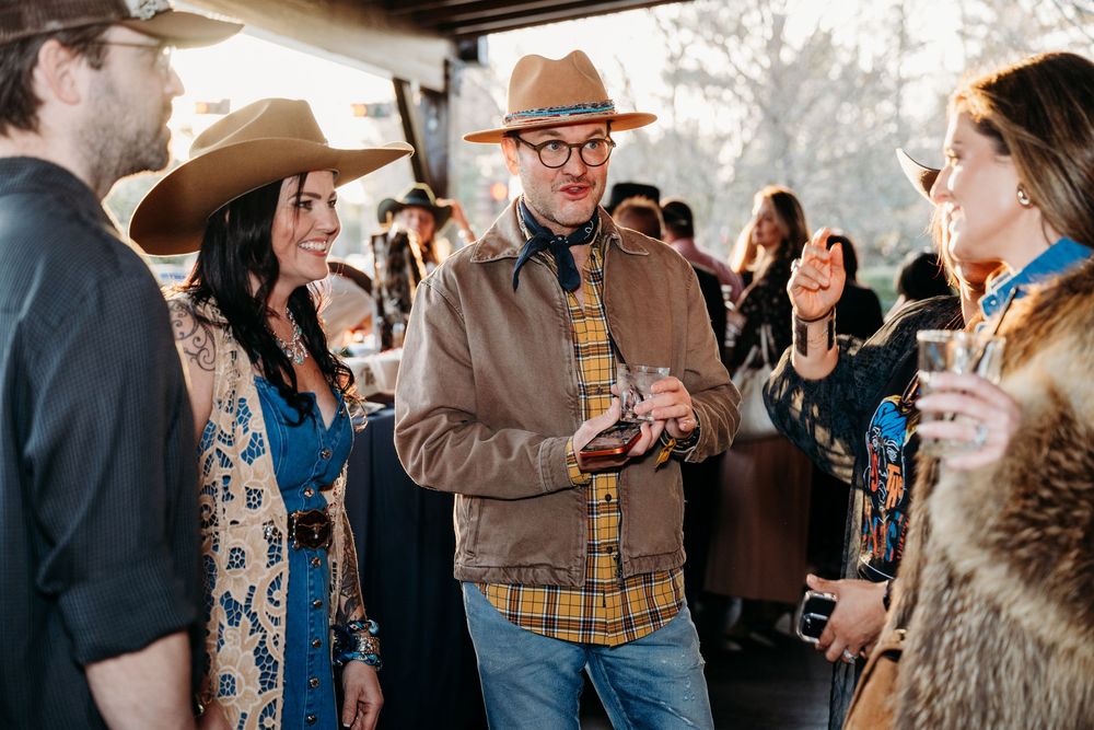 Group engaged in lively conversation at a western-themed indoor gathering.