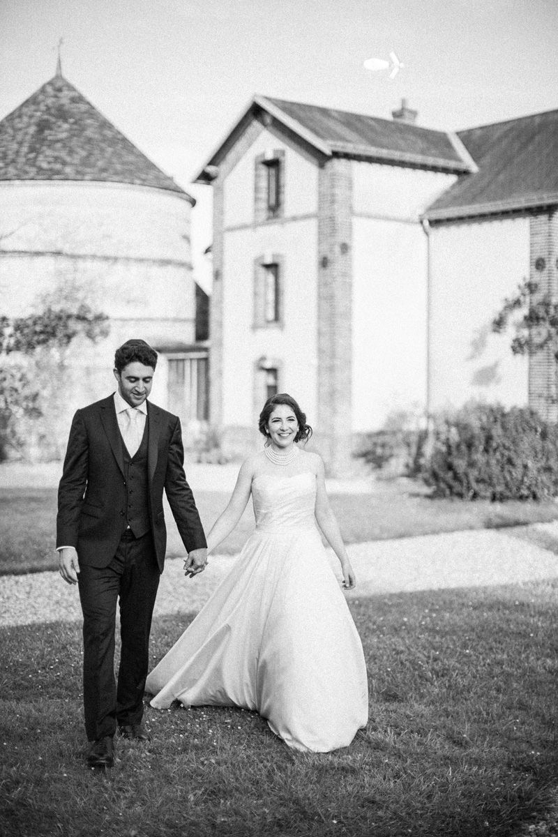 Bride and groom walking through the grounds of Château Barthélemy near Paris