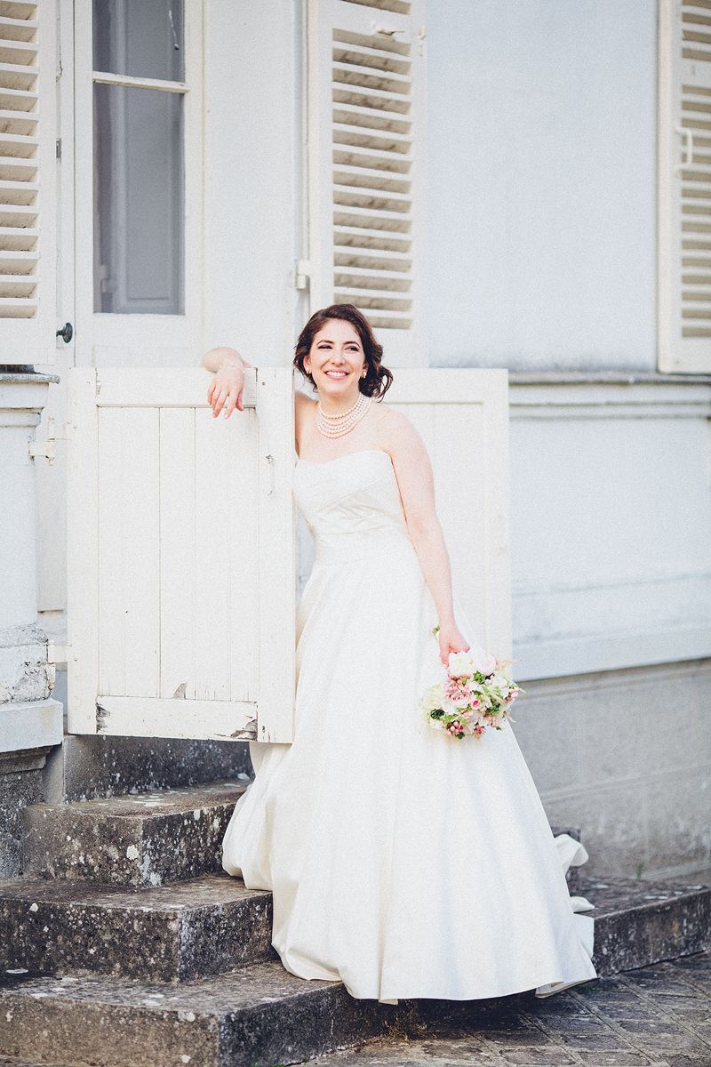 Bride holding her bouquet outside Château Barthélemy wedding venue near Paris