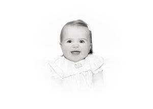 Three black and white photographs of a baby smiling and making different expressions.