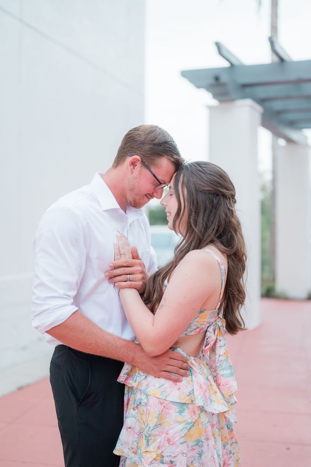 A romantic couple embraces during what appears to be a proposal or special moment outdoors.
