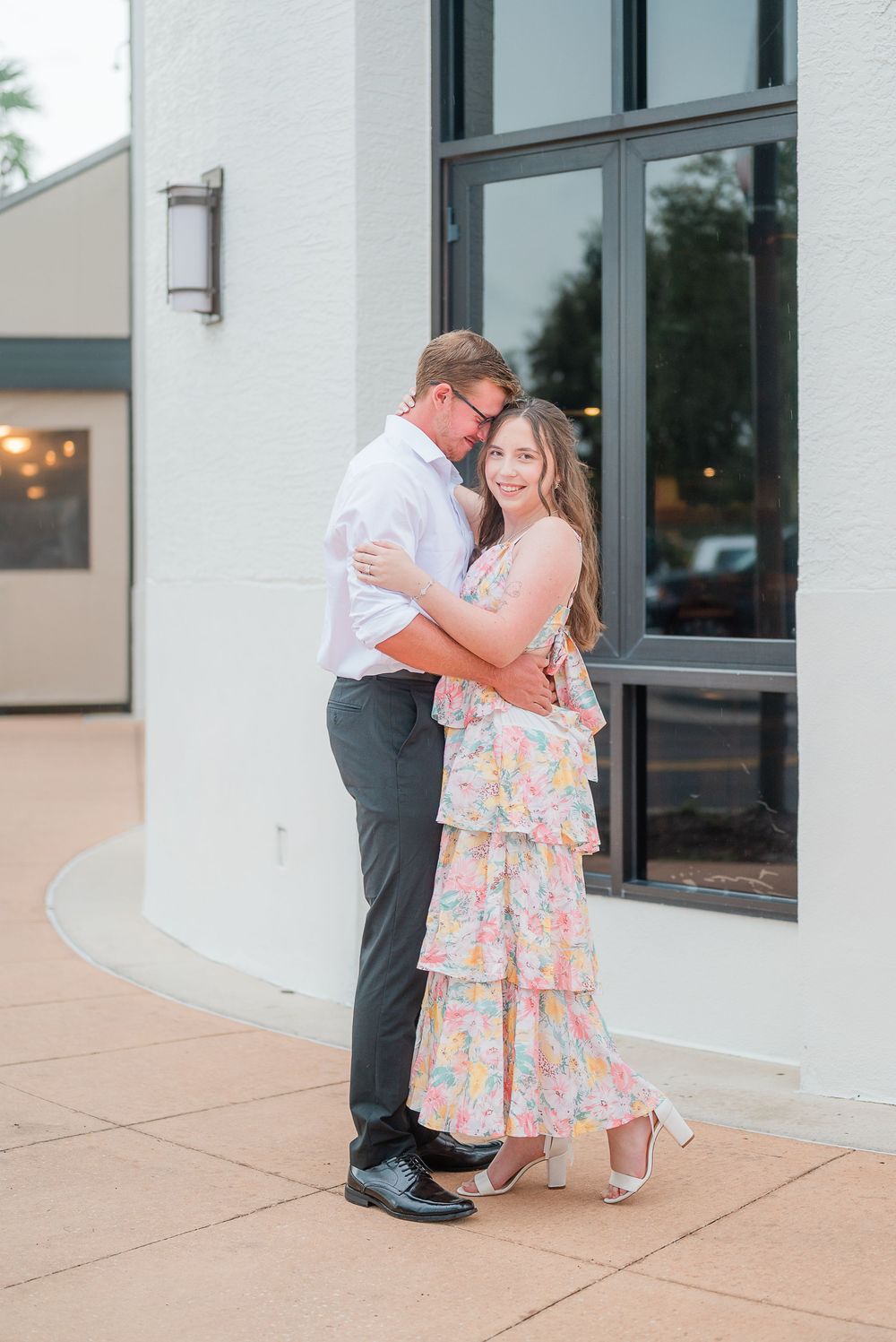 A couple shares an intimate moment outside a building in a series of romantic poses.
