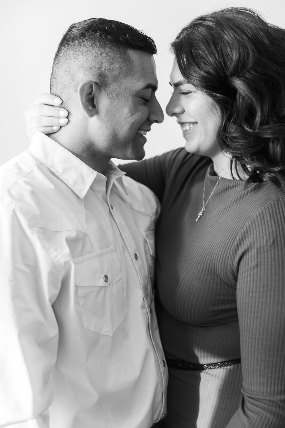 A romantic black and white portrait of a couple sharing an intimate moment together.