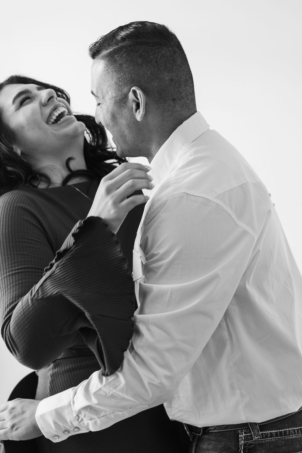 A romantic black and white photo series showing an intimate couple embracing and laughing together.