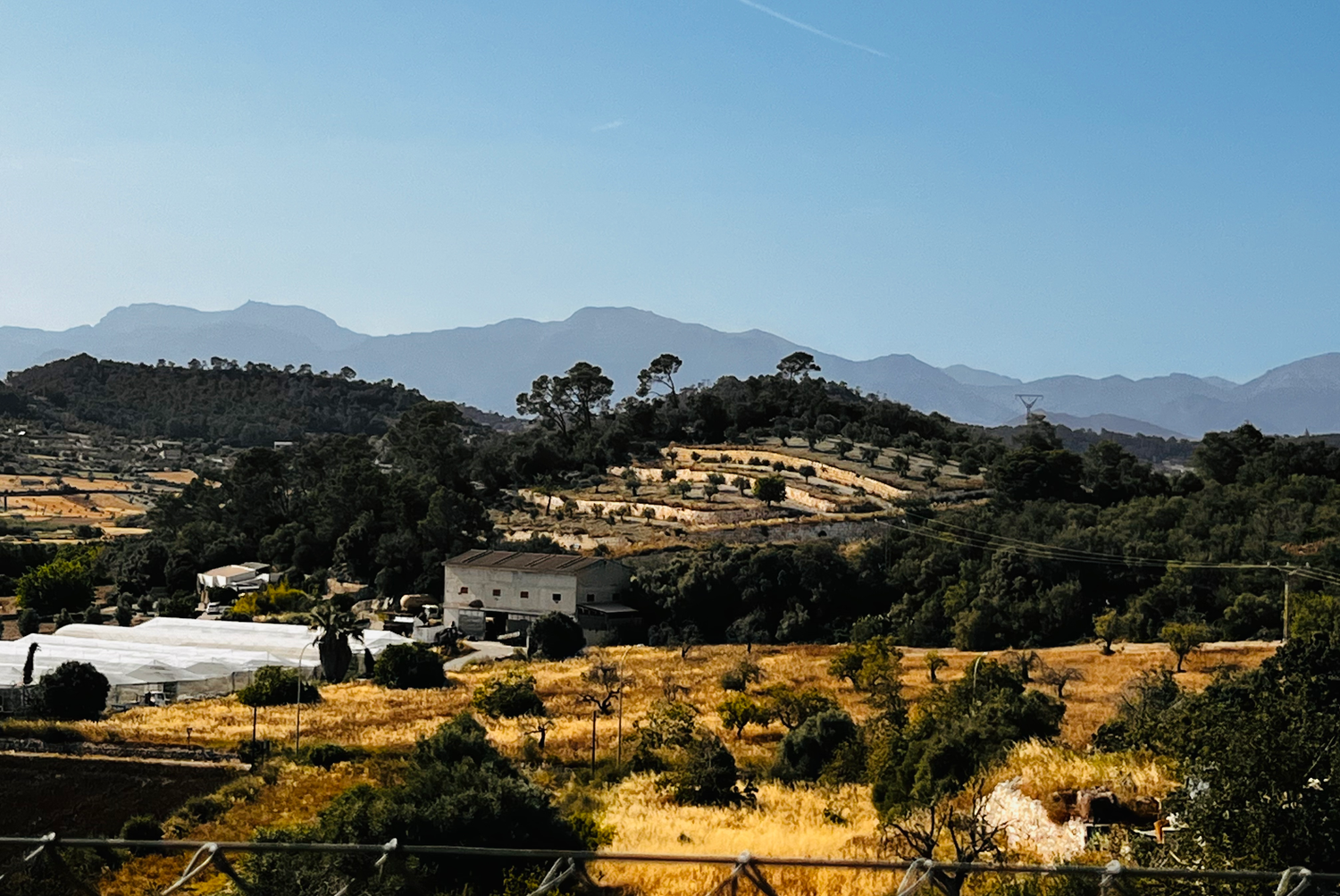 Stunning coastal villa development overlooking Mediterranean Sea during golden sunset with mountains in background.