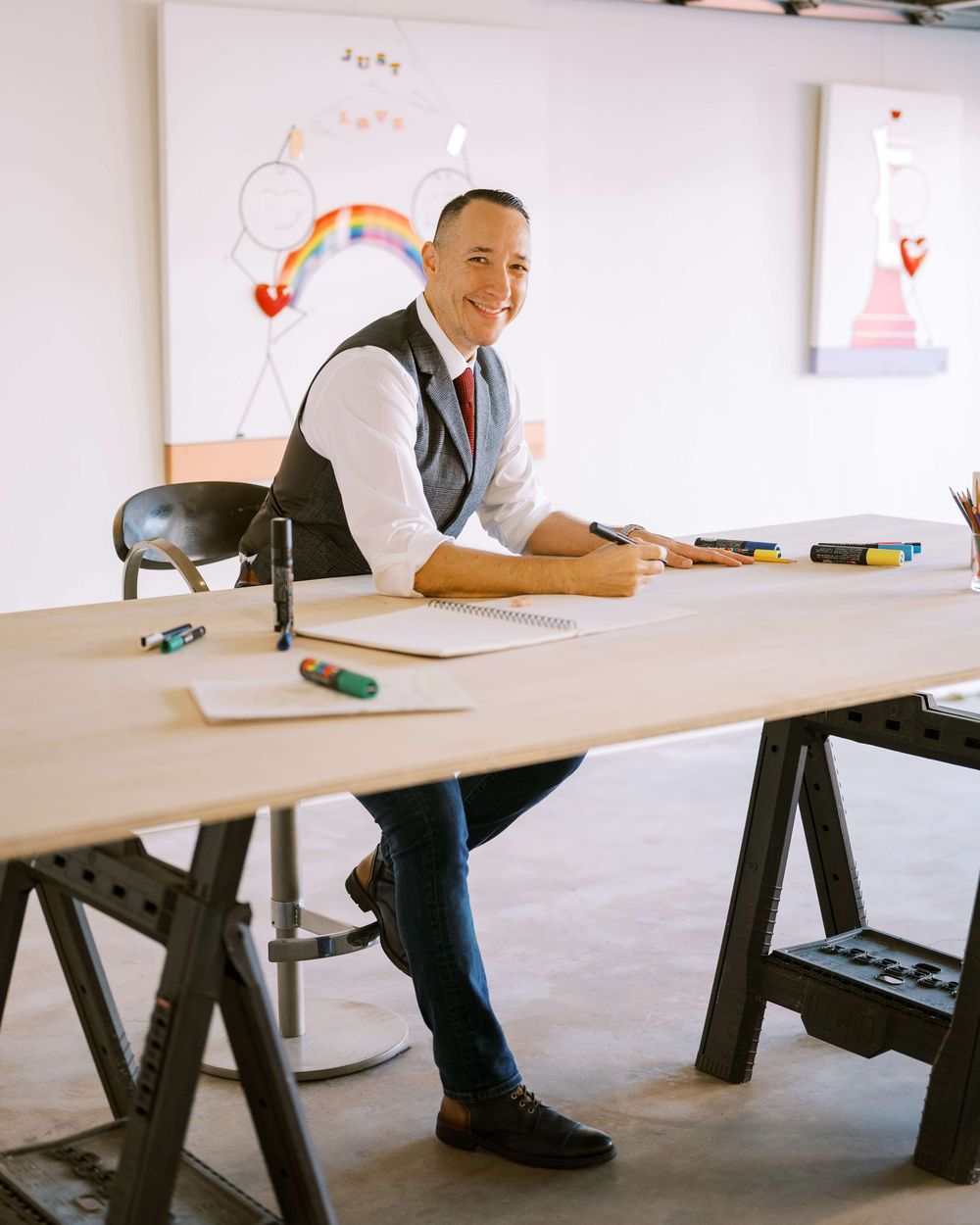 Children's author and artist Daniel Molina poses at his desk in his studio.