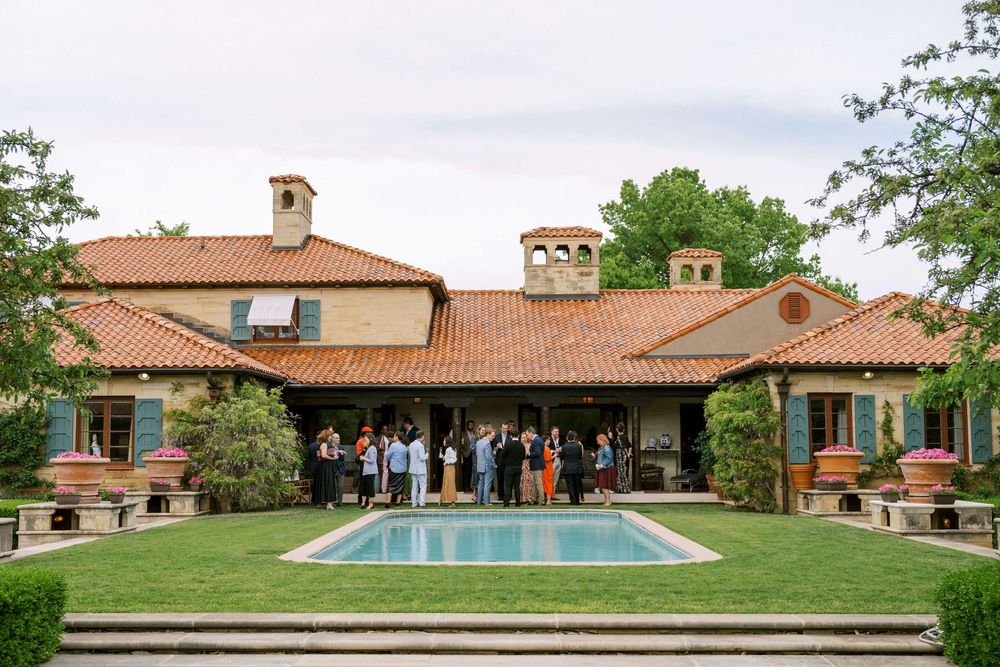 Guests mingle in front of a historic estate with a pool, to support the Calderon Dance Festival.