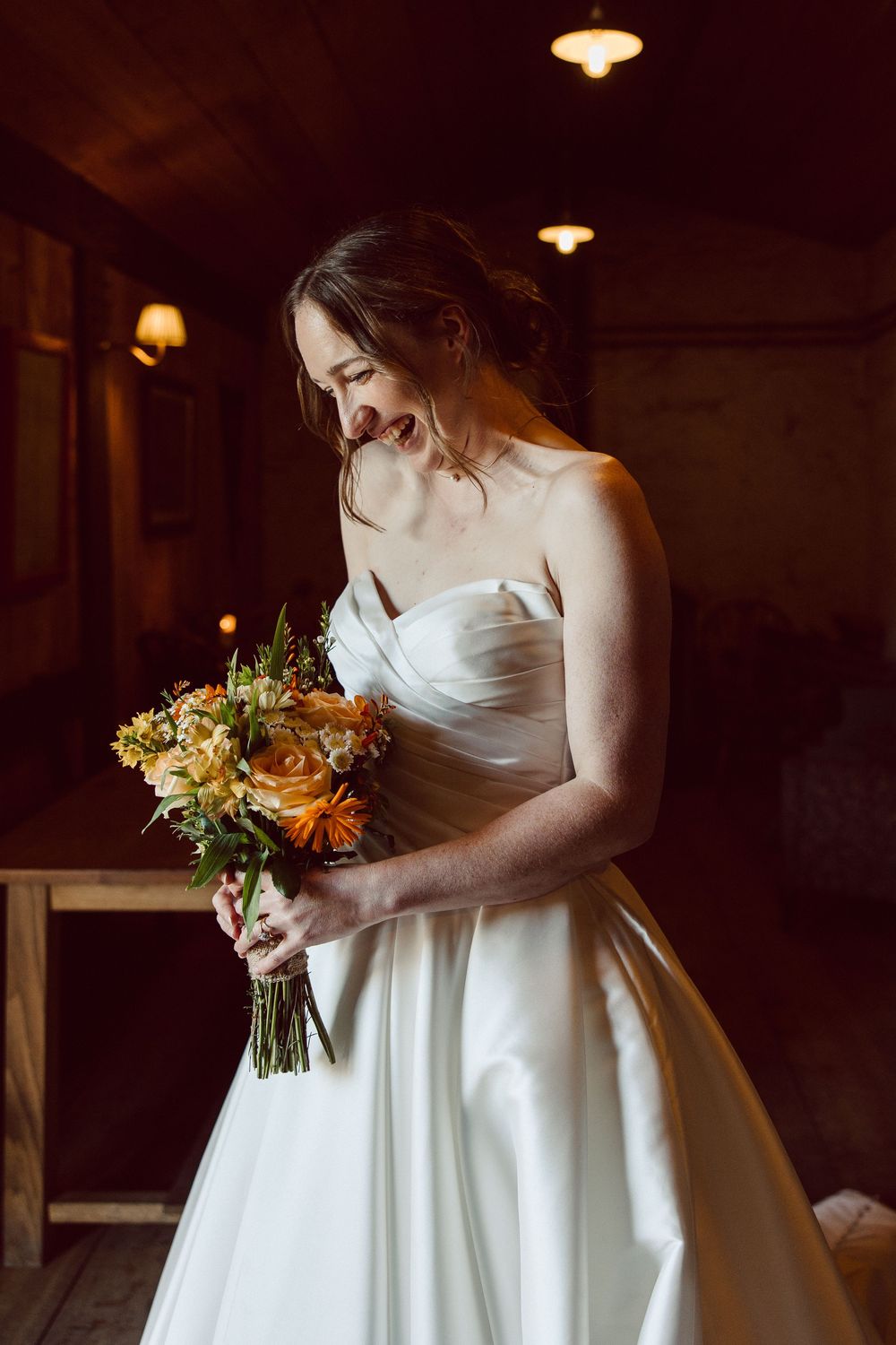 A series of photos showing a bride in a white wedding dress holding an autumn-colored bouquet in a dimly lit venue.