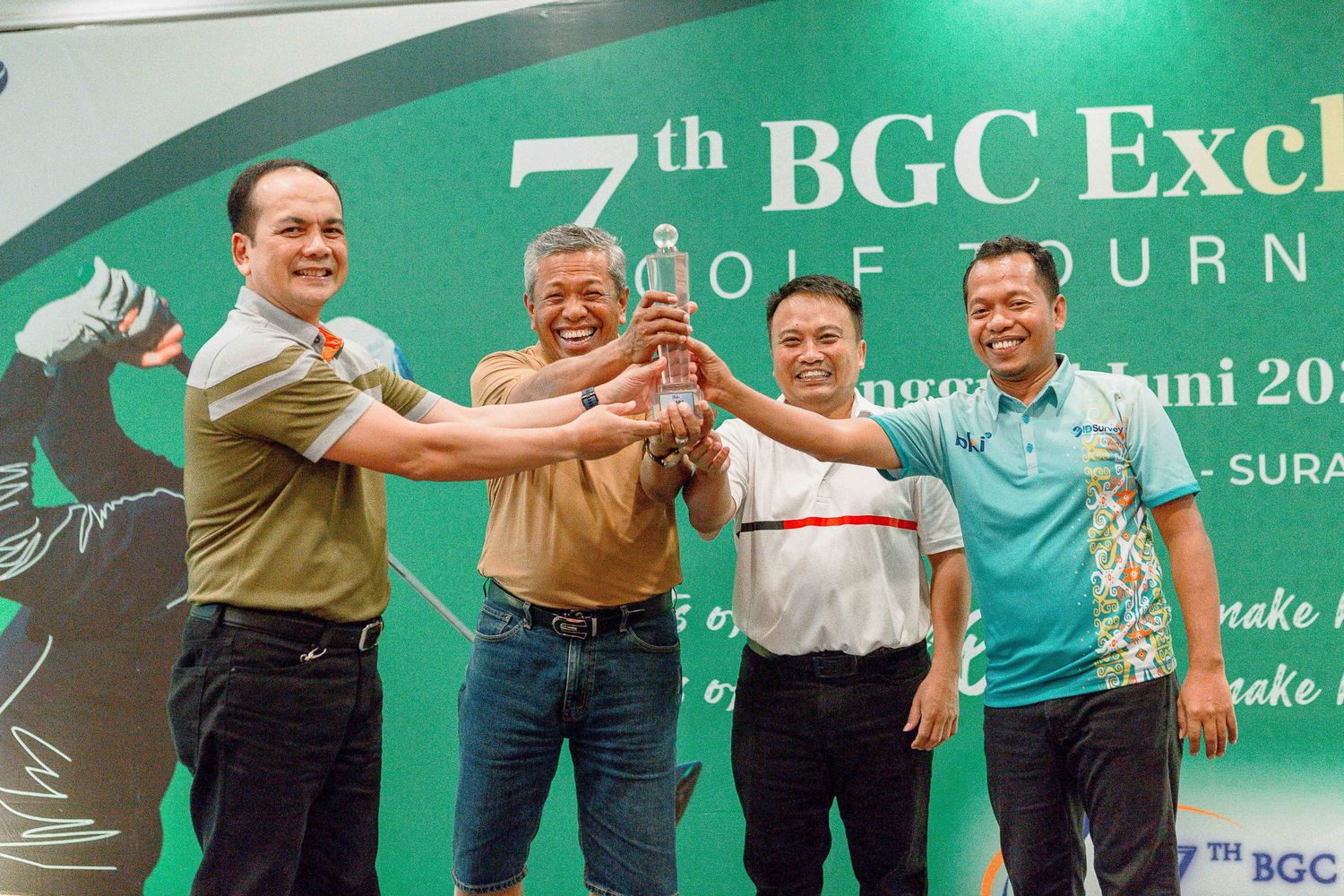 Group of people jumping and posing excitedly in front of a green backdrop at a BGC corporate event.