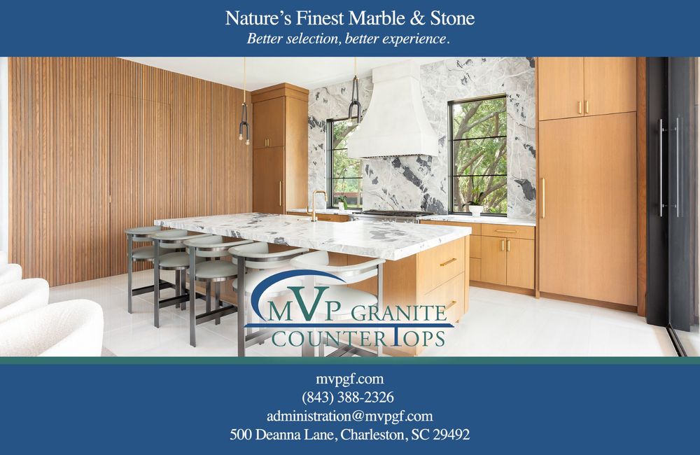 Modern kitchen interior with marble backsplash, wooden cabinets and island seating in bright natural lighting.