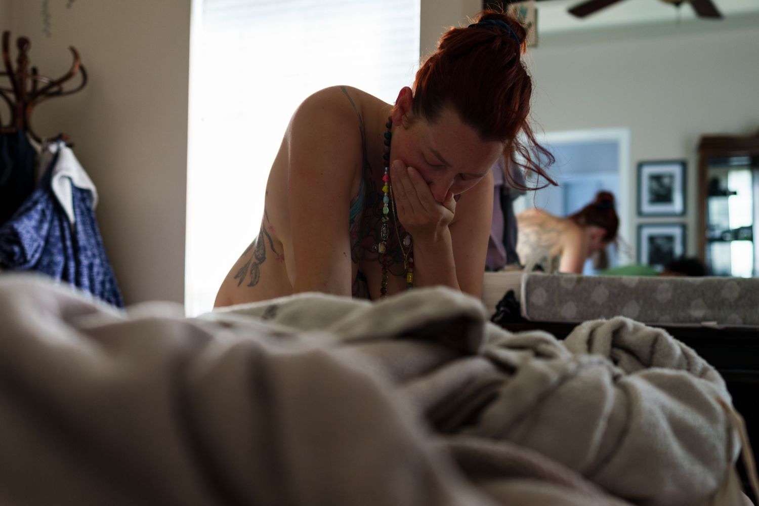A person lies in bed with soft natural light streaming through the window during a quiet morning moment.