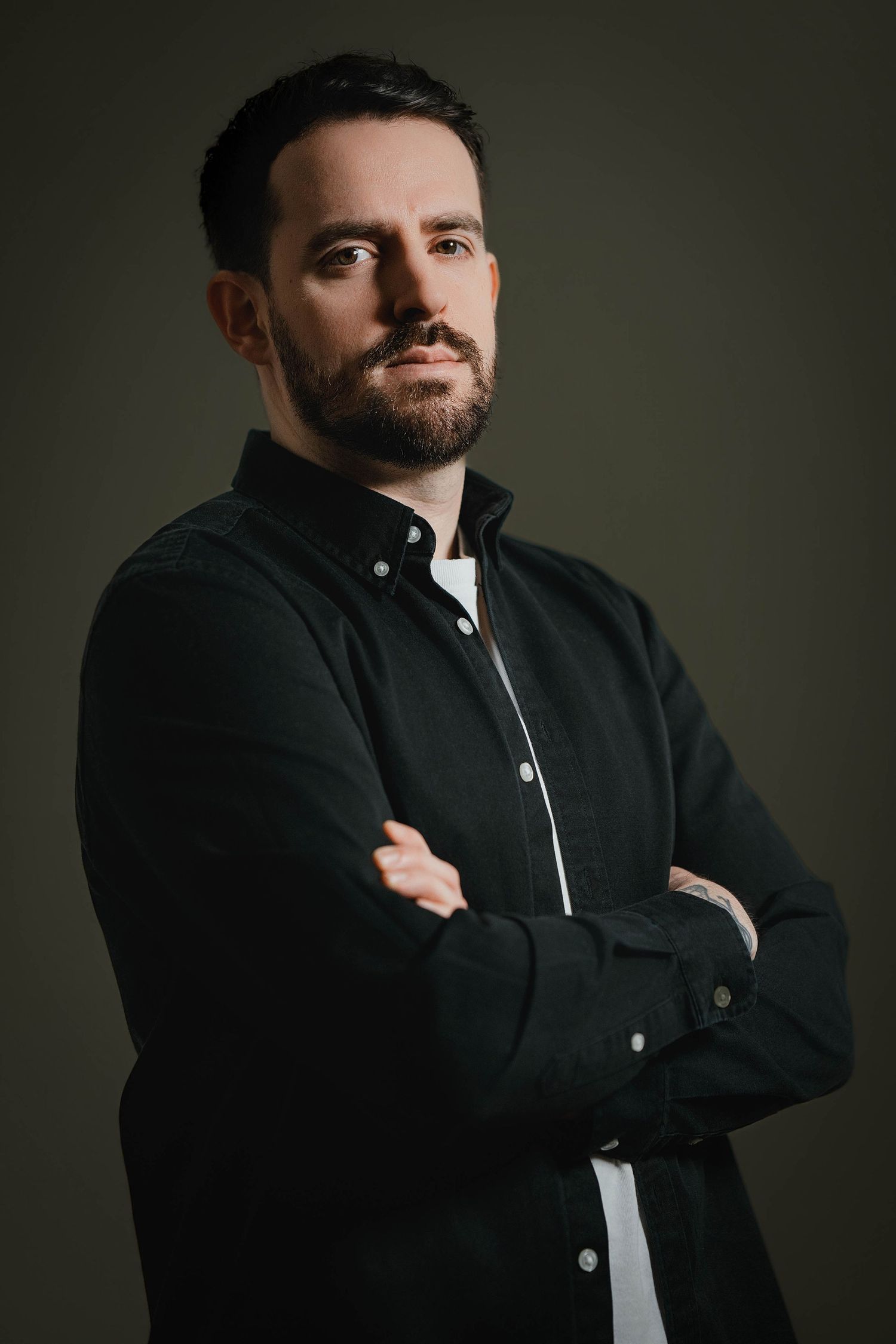 Professional studio portrait series showing a figure in a black button-up shirt against a dark background.